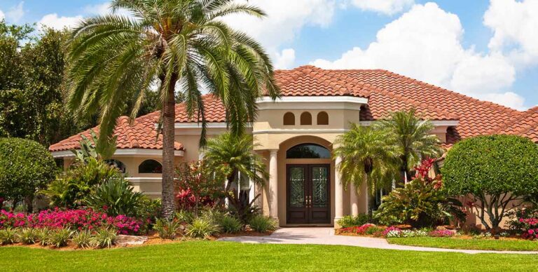 Front of home on sunny day with palm trees