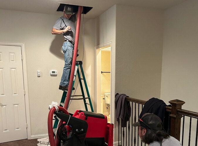 Technician working on HVAC equipment inside a home