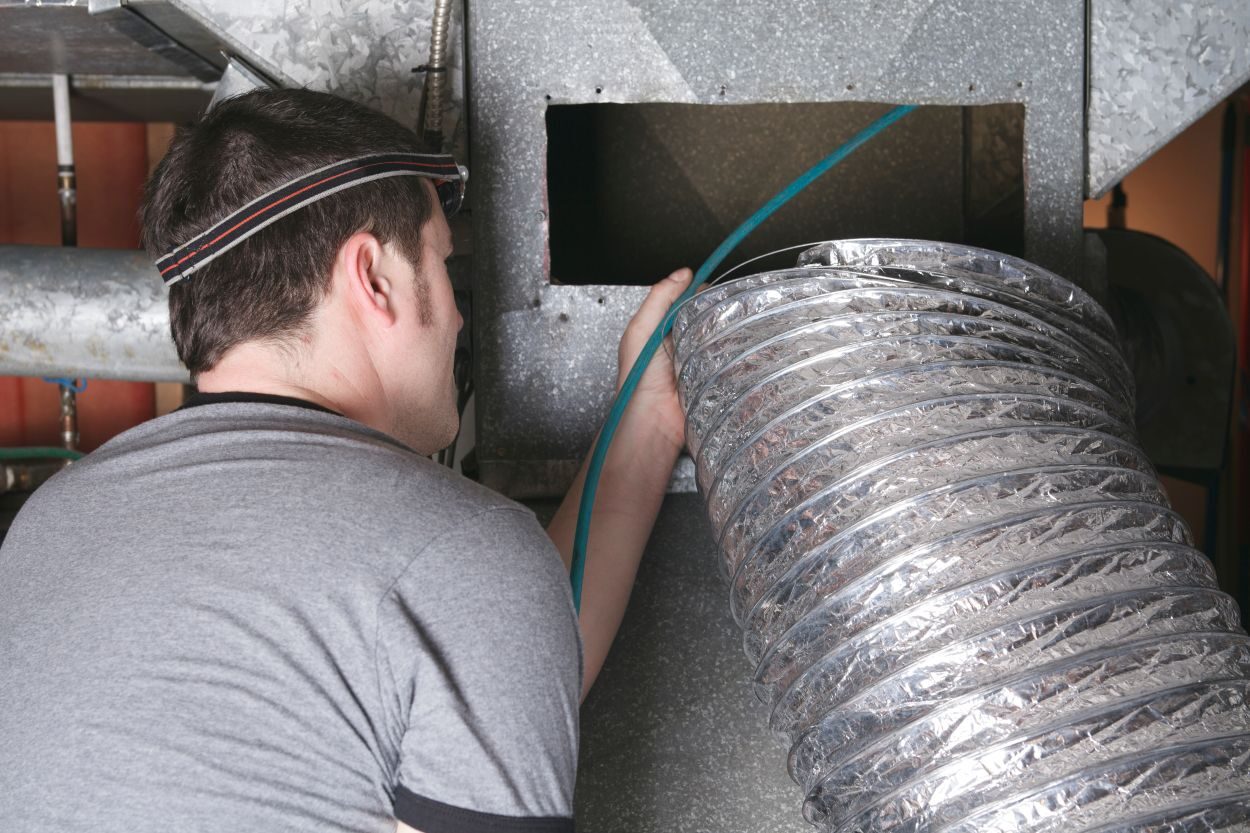 A ventilation cleaner man at work with tool